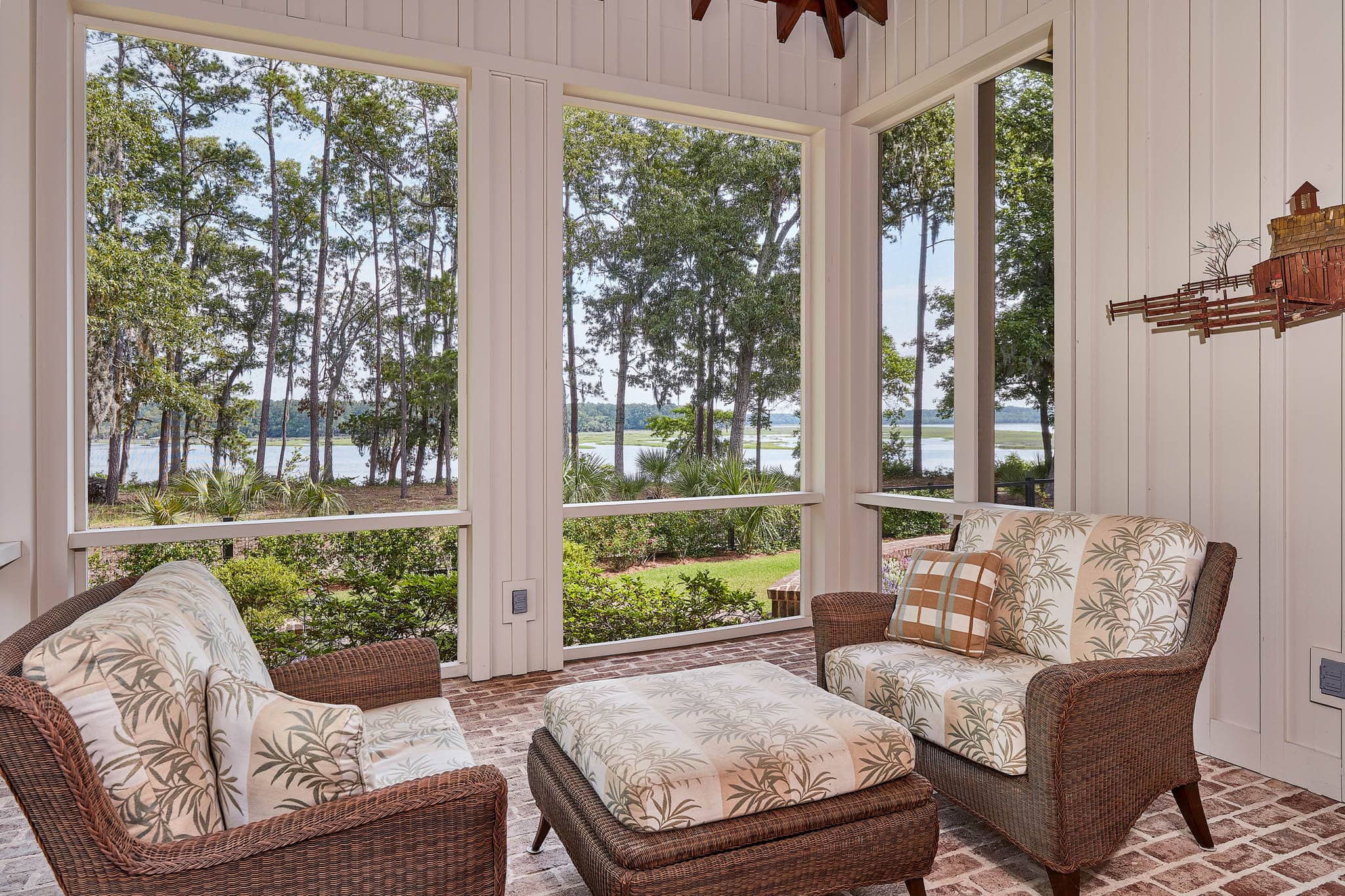 Screened in porch with chairs and overlooking lowcountry