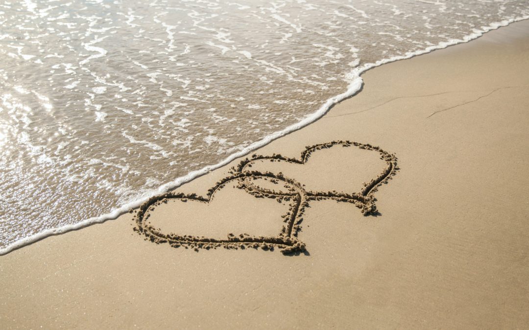 Two hearts drawn in the sand on the beach